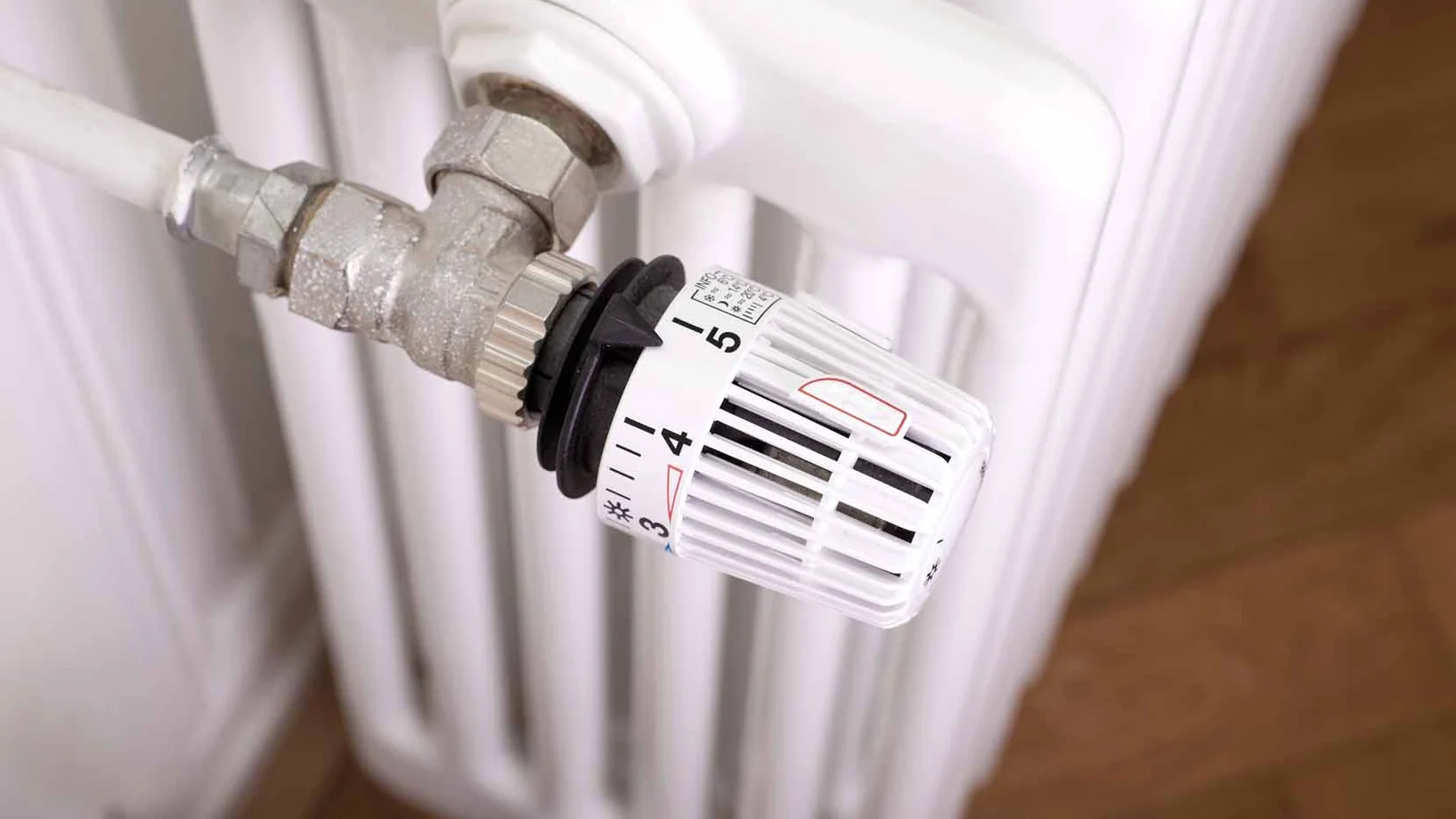 Ein Radiator von oben mit einem Ventil um die Heizung zu regulieren. Alles in weiss